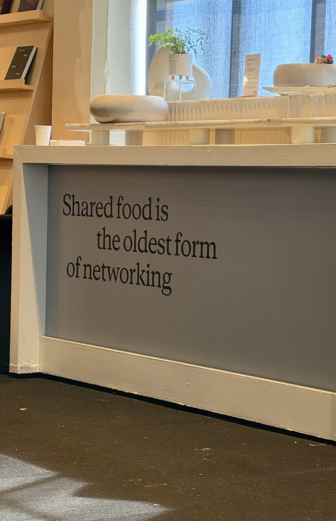A sign at Claude Founder House reading Shared food is the oldest form of networking.